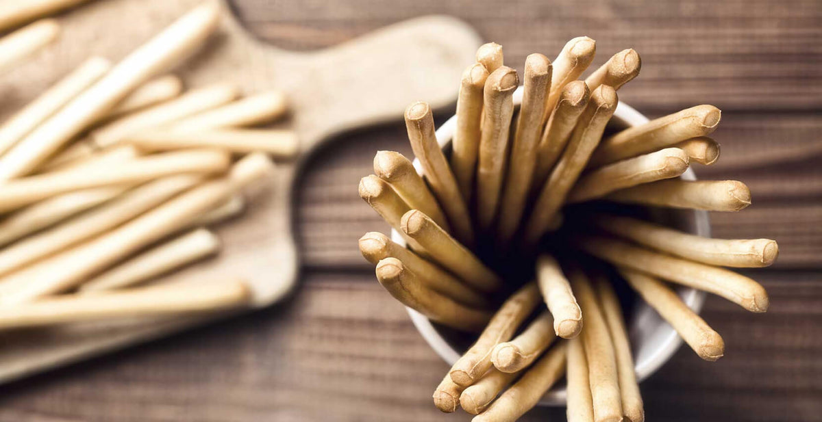 Granforno breadsticks in a cup on a wooden table