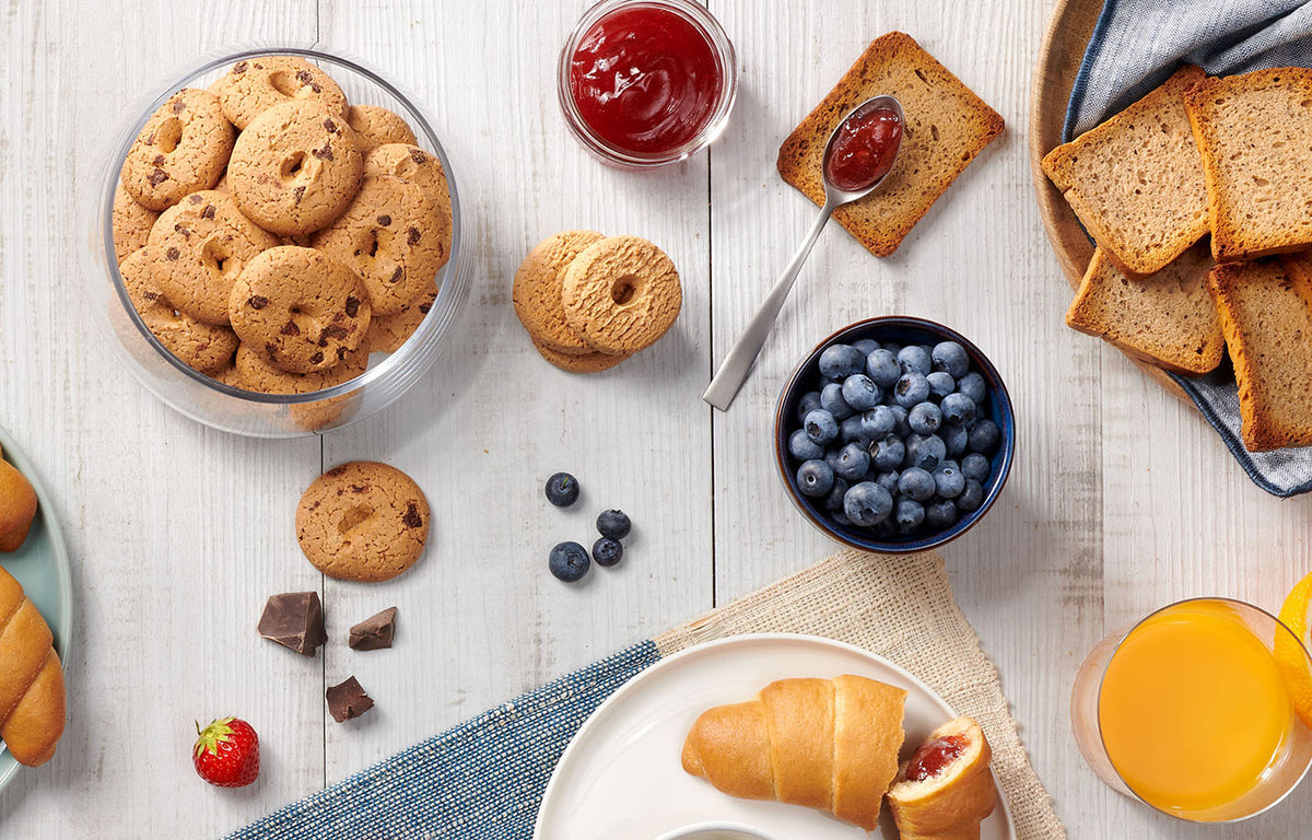 Nutrifree biscuits, jam and breakfast favourites on a light wooden table