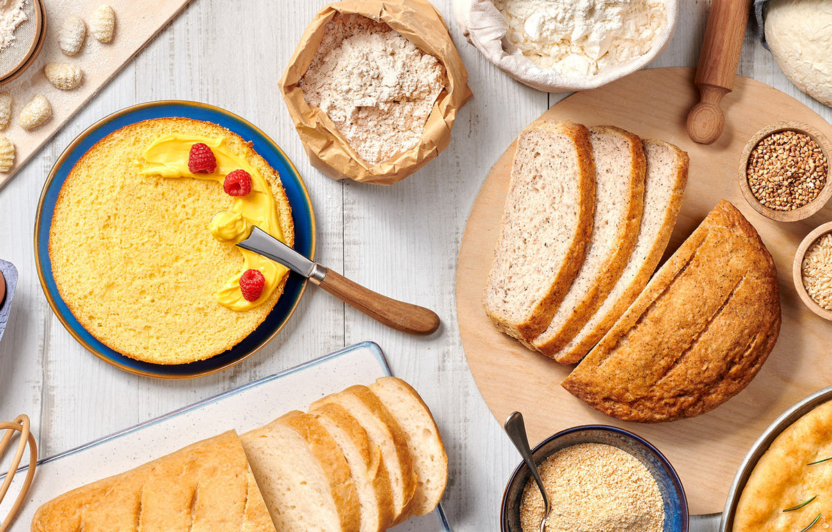 Flour, grains, dough and freshly baked bread on a baking table, photographed by Nutrifree